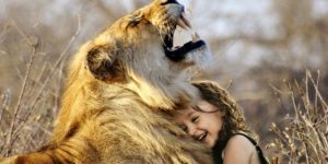 Kleines Mädchen mit einem Löwen in Afrika