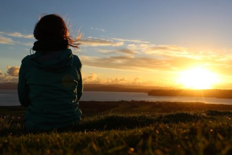 Eine Person vor einem Sonnenaufgang