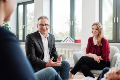 Menschen sitzen im Stuhlkreis und besprechen etwas